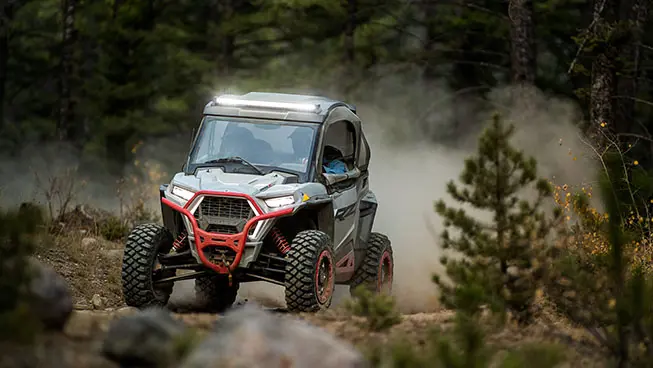 RZR Trail side by side cruising on a forest trail
