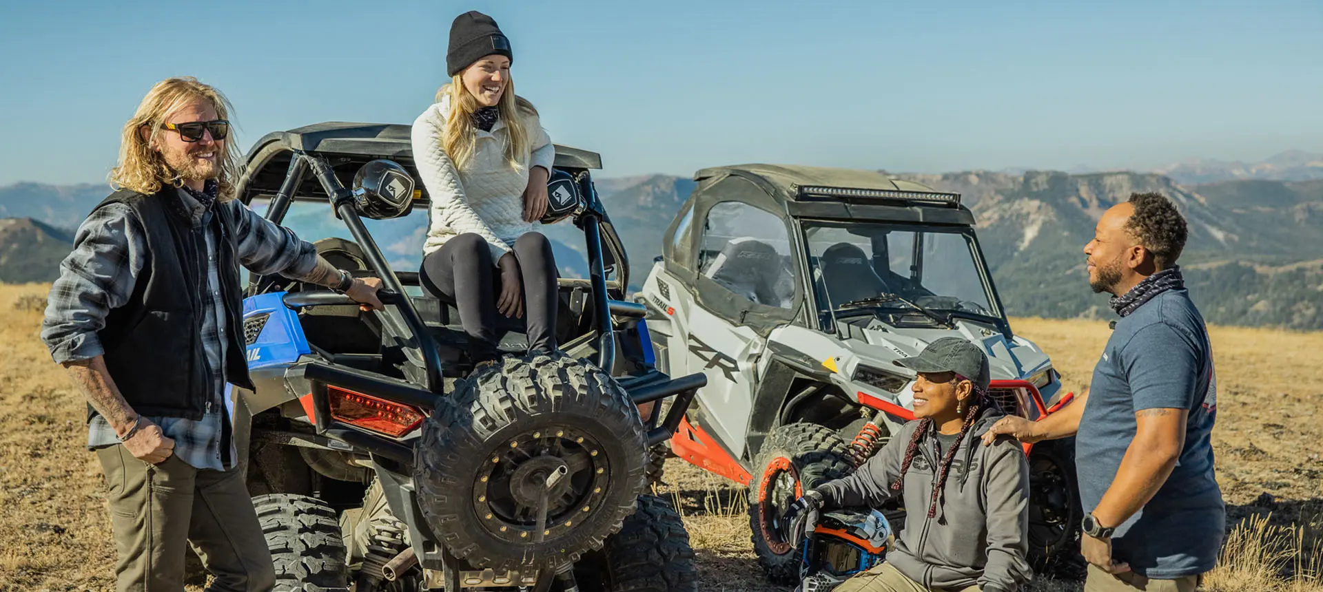 amigos pasando el rato después de un paseo en sus Side by Side RZR Trail y RZR Trail S