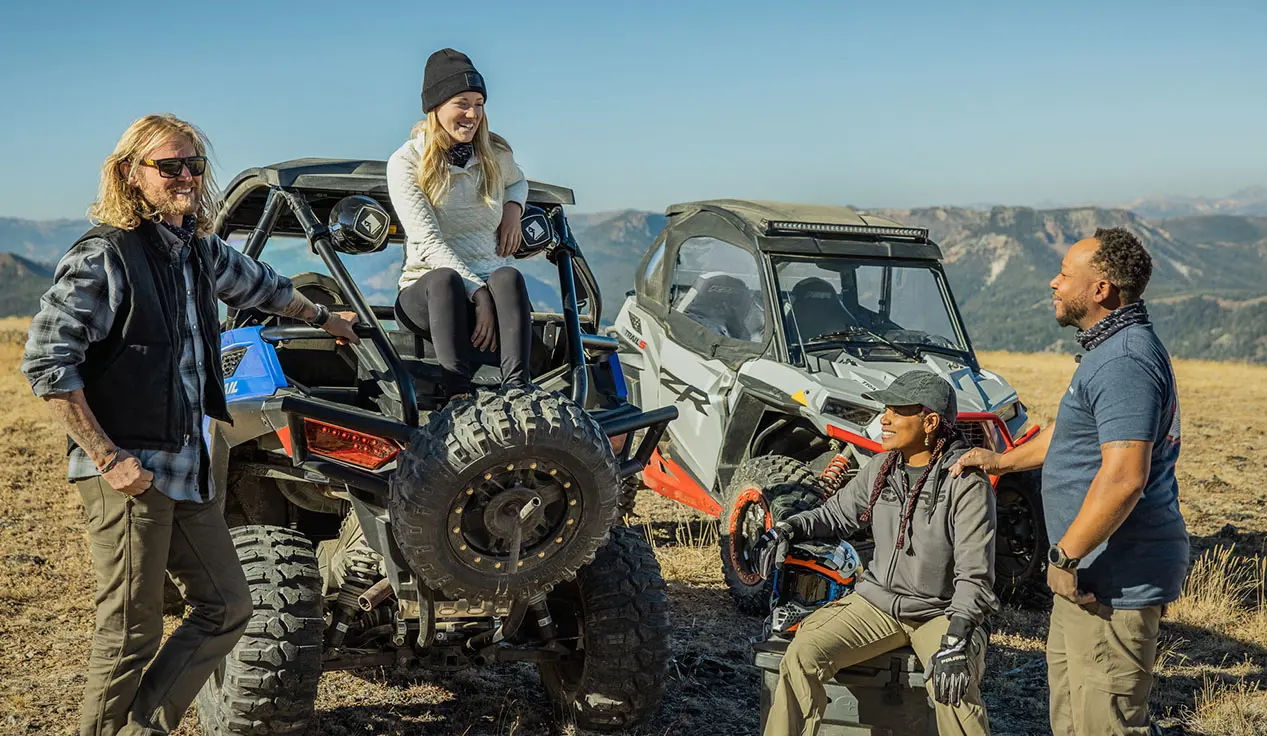 amigos pasando el rato después de un paseo en sus Side by Side RZR Trail y RZR Trail S