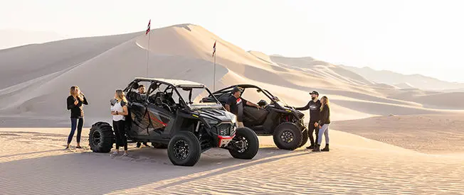 amigo descansando cerca de su side by side rzr turbo r 4 en el desierto