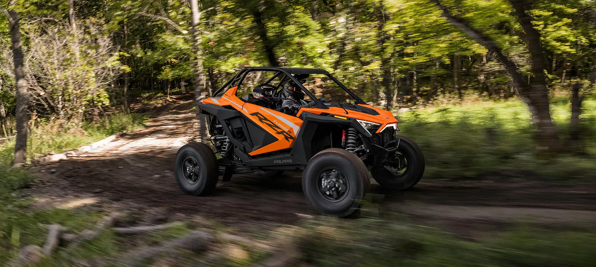 côte à côte polaris RZR Turbo R circulant dans la forêt