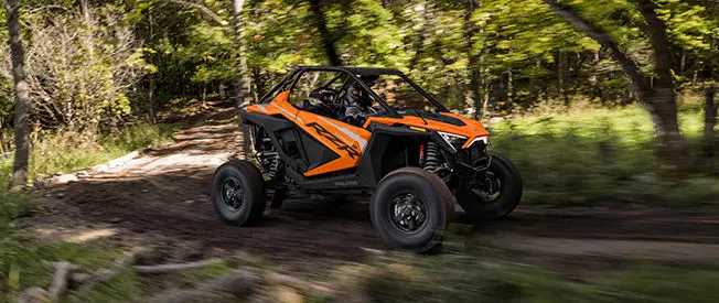 côte à côte polaris RZR Turbo R circulant dans la forêt