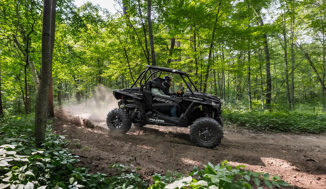 RZR XP 1000 avec 2 personnes sur un sentier forestier