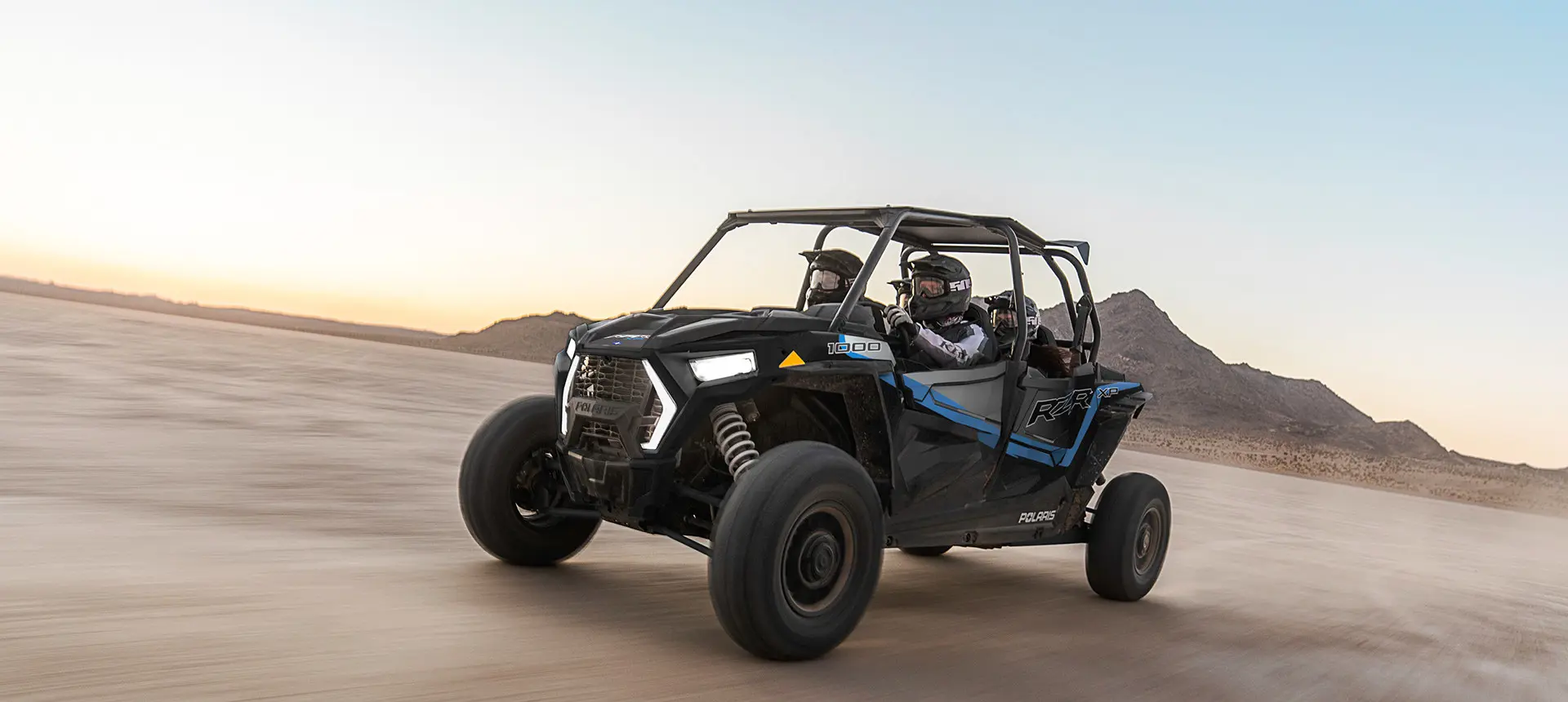 sunset red rzr xp 4 1000 with 4 passengers in the dunes