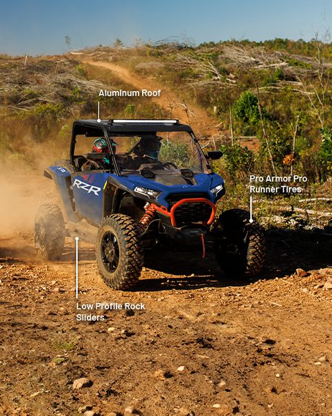 Aluminum Roof, RIGID 32-inch combo LED Light Bar, Pro Armor Pro Runner Tires, and Low Profile Rock Sliders from the Backcountry package installed on a blue 2025 Polaris RZR XP side by side.