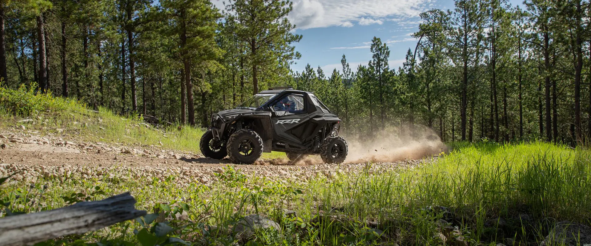 side view of a polaris rzr pro xp side by side on a forest trail