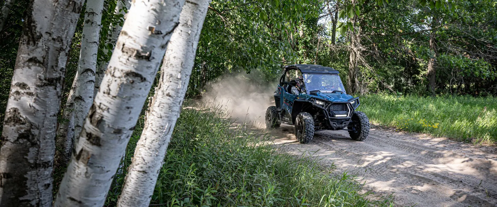 polaris rzr trail s side by side cruising down a forest trail