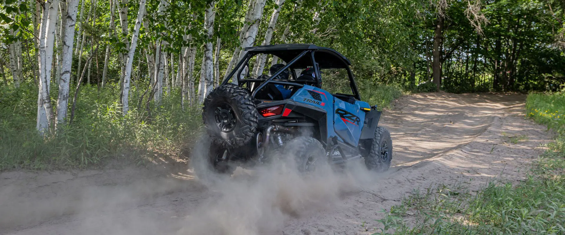 rear end of a polaris rzr trail s side by side on a trail