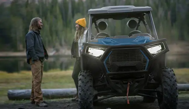 people standing behind their polaris rzr trail side by side