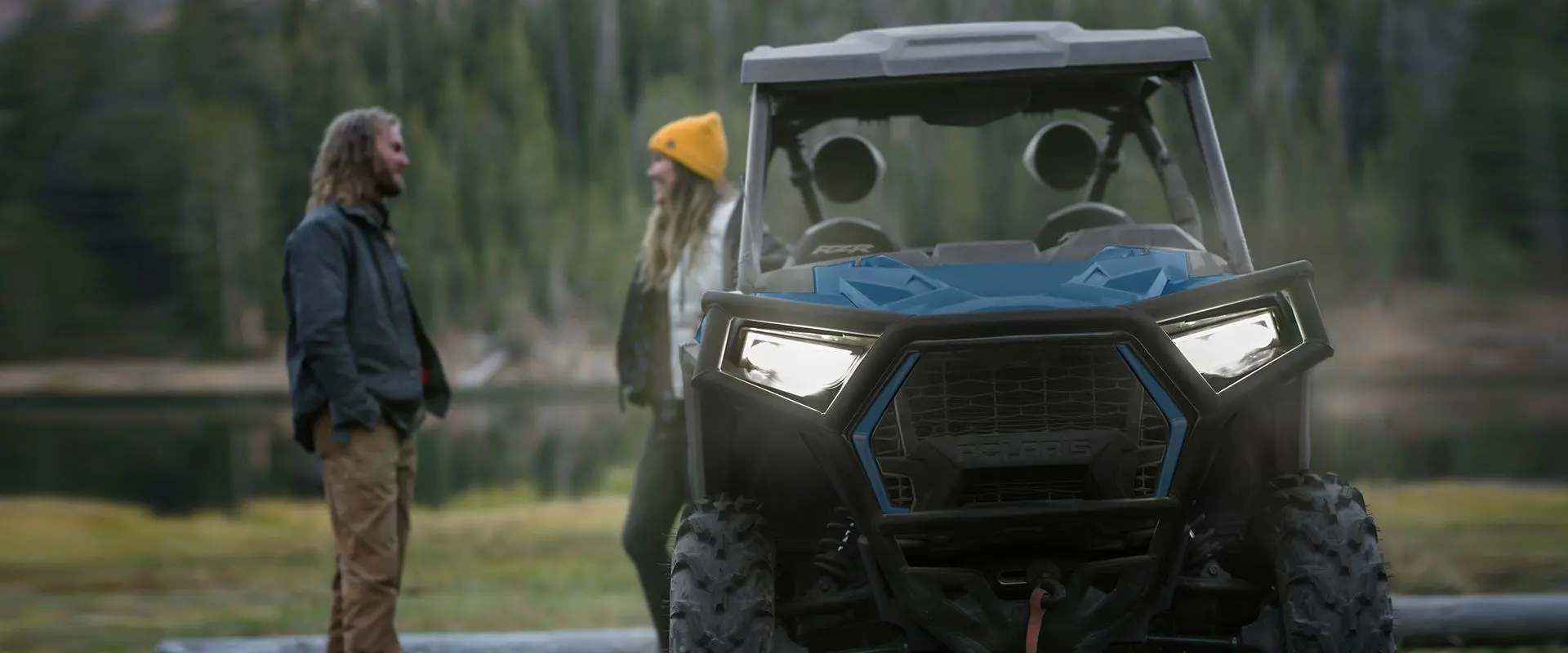 people standing behind their polaris rzr trail side by side