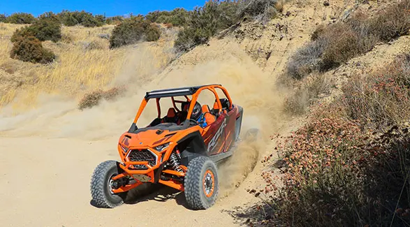 2025 Polaris RZR Pro R 4 Factory Armored Edition side-by-side driving through the desert.