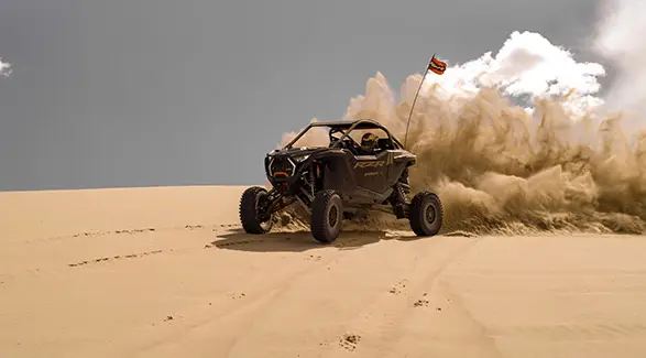 2025 Polaris RZR Pro R side-by-side throwing sand in the desert.