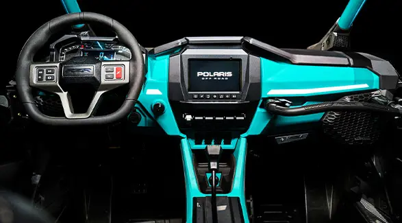 Interior view of the dashboard and steering wheel of a 2025 Polaris RZR Pro R 4 side-by-side.