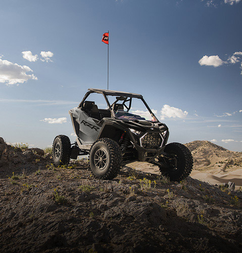 A 2026 Polaris RZR SxS parked on a hill showcasing its bold design.