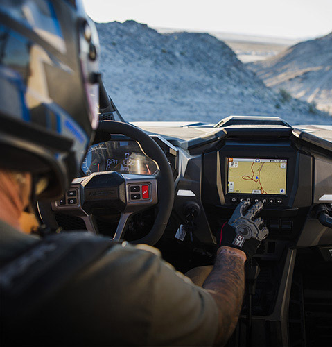 A rider using the RIDE COMMAND technology inside a 2026 Polaris RZR side-by-side.