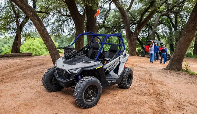 A 2026 Polaris RZR 200 EFI youth SxS with a helmet on the hood.