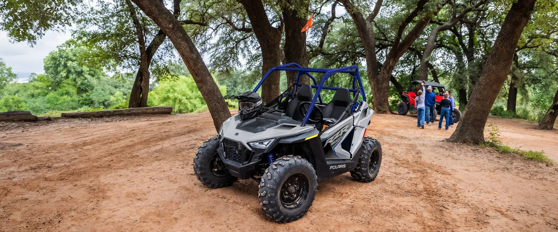 A 2026 Polaris RZR 200 EFI youth SxS with a helmet on the hood.