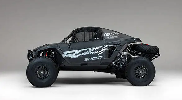 Side view of a 2027 Polaris RZR Pro R Factory Boost SxS featuring carbon fiber bodywork and rear spare tire.