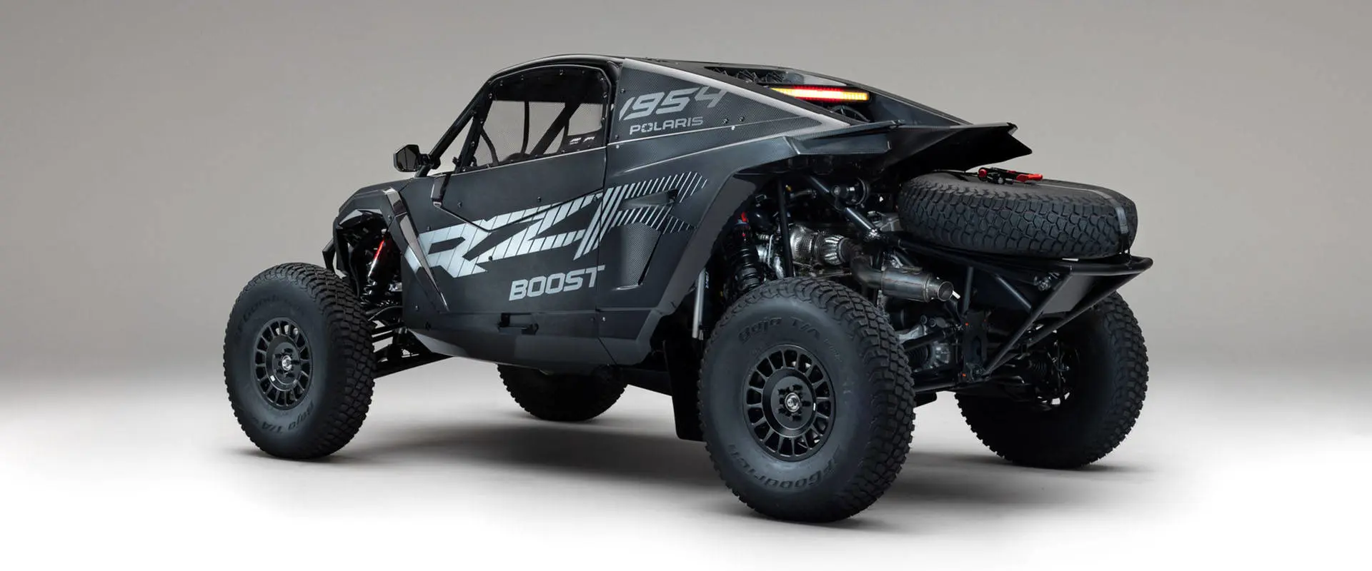 Rear view of a 2027 Polaris RZR Pro R Factory Boost side-by-side with exposed suspension, exhaust and spare tire.