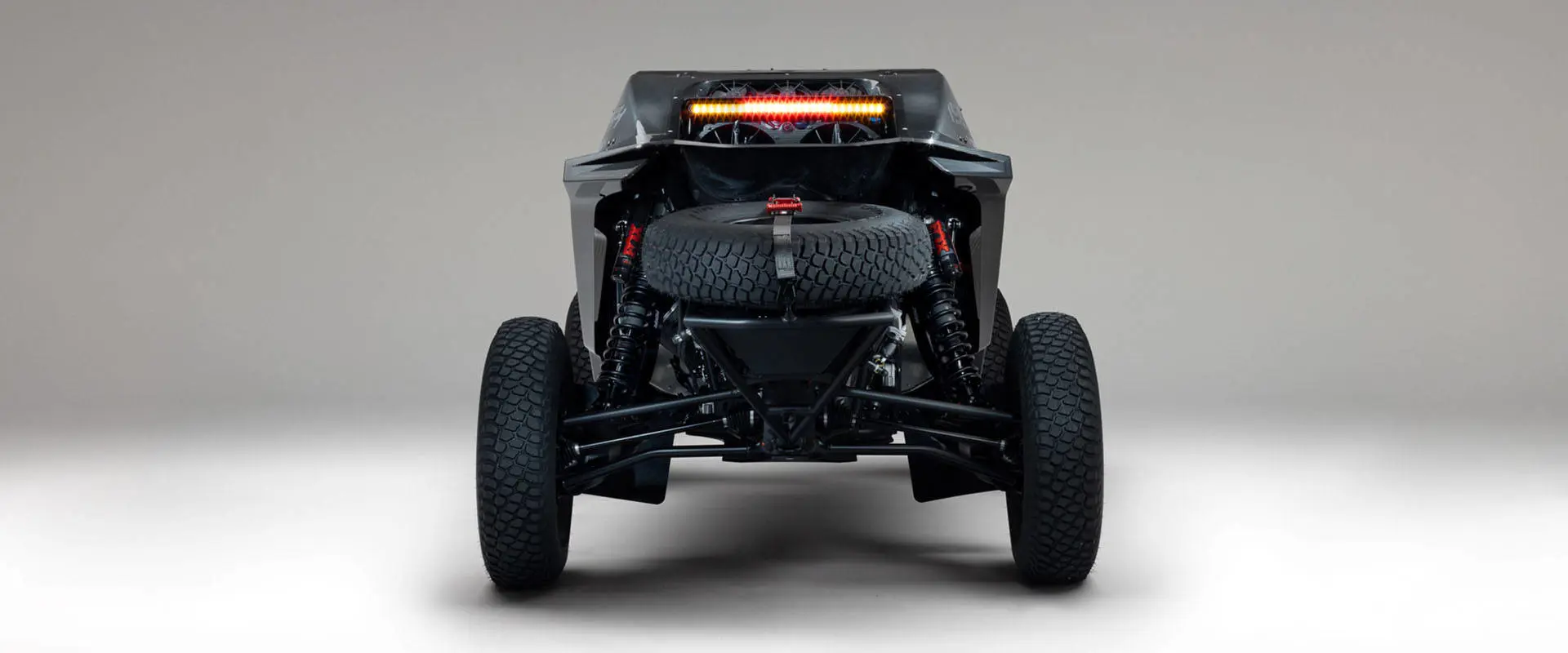 Rear view of a 2027 Polaris RZR Pro R Factory Boost SxS featuring a spare tire, suspension and illuminated rear light bar.