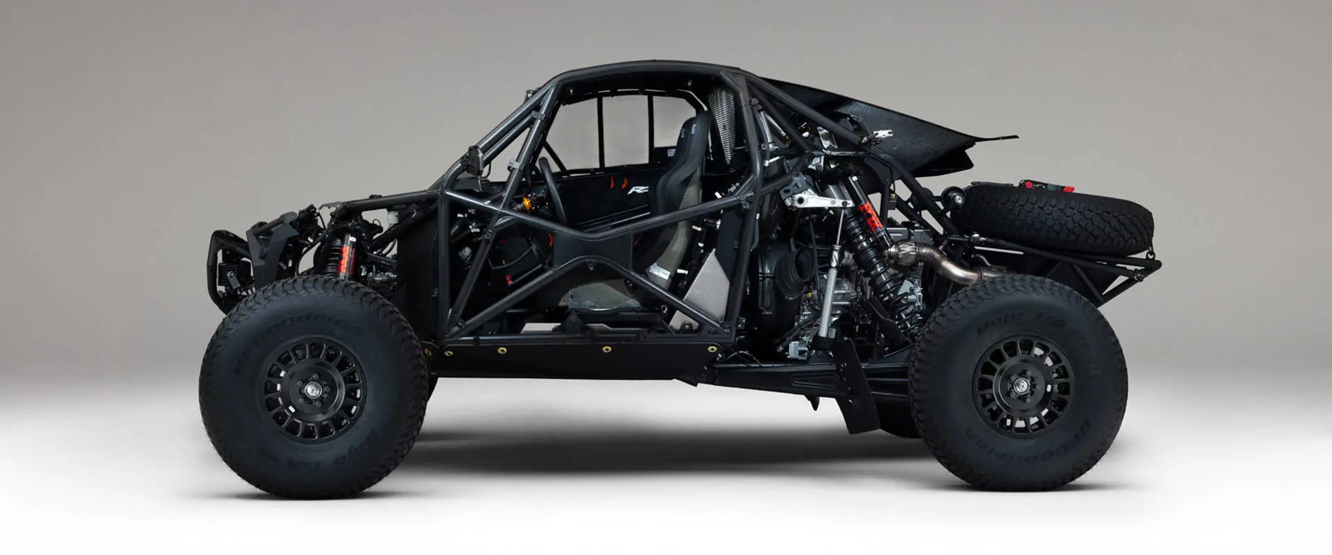 Side view of a 2027 Polaris RZR Pro R Factory Boost side-by-side with exposed roll cage, suspension and powertrain.