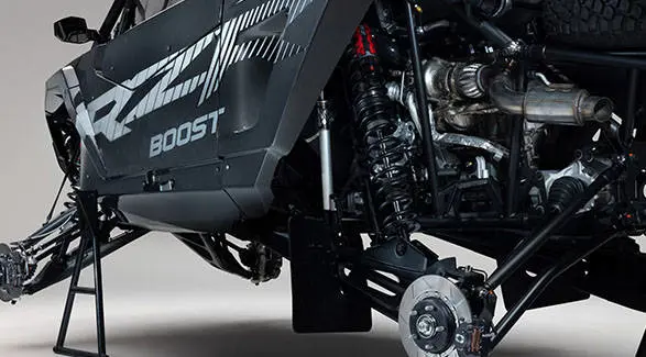 Close-up of the front and rear suspension, brake assemblies and powertrain on a 2027 Polaris RZR Pro R Factory Boost SxS.