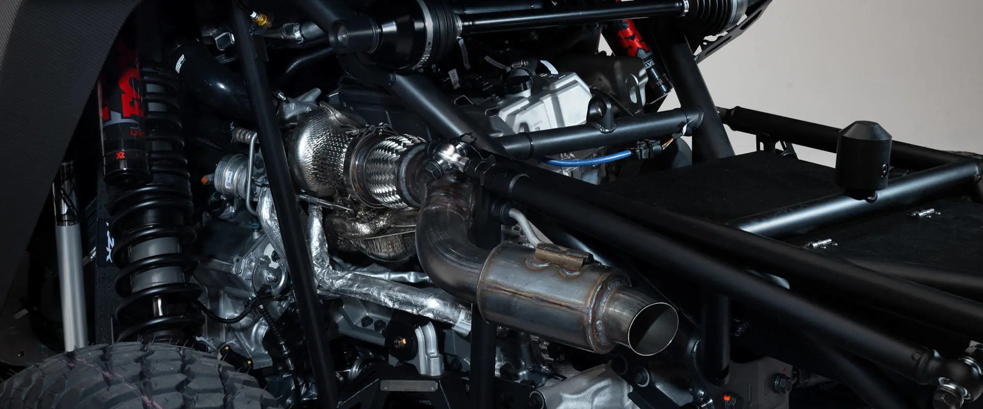 Close-up of the turbocharged engine and exhaust system on a 2027 Polaris RZR Pro R Factory Boost SxS.