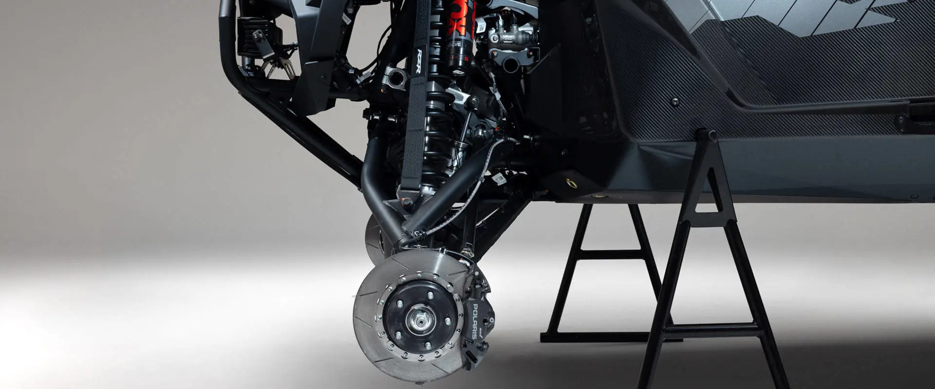 Close-up of the front suspension and brake assembly on a 2027 Polaris RZR Pro R Factory Boost side-by-side.