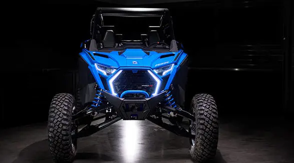 Front view showing the glowing C-shaped LED headlights and aggressive grille of the RZR Pro R Ultra Edition Velocity Blue.