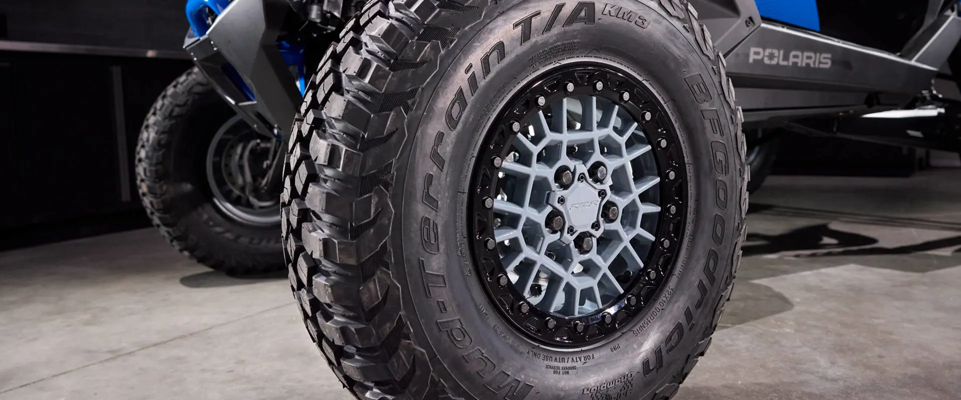 Close-up detail of a BFGoodrich Mud-Terrain T/A KM3 tire and custom wheel on the RZR Pro R Ultra Edition Velocity Blue SxS.