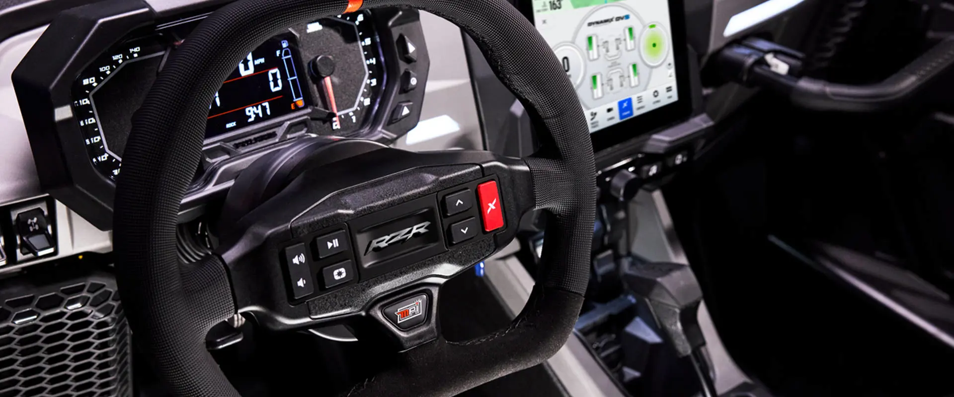 Cockpit detail showing the RZR-branded steering wheel and digital instrument cluster.