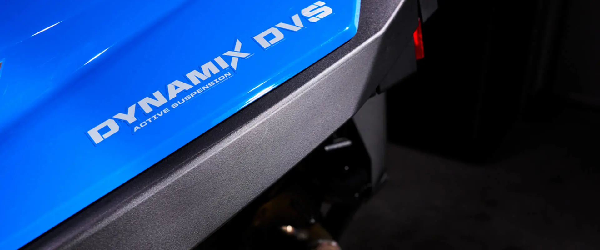 Graphic detail showing the DYNAMIX DVS ACTIVE SUSPENSION decal on the blue bodywork.