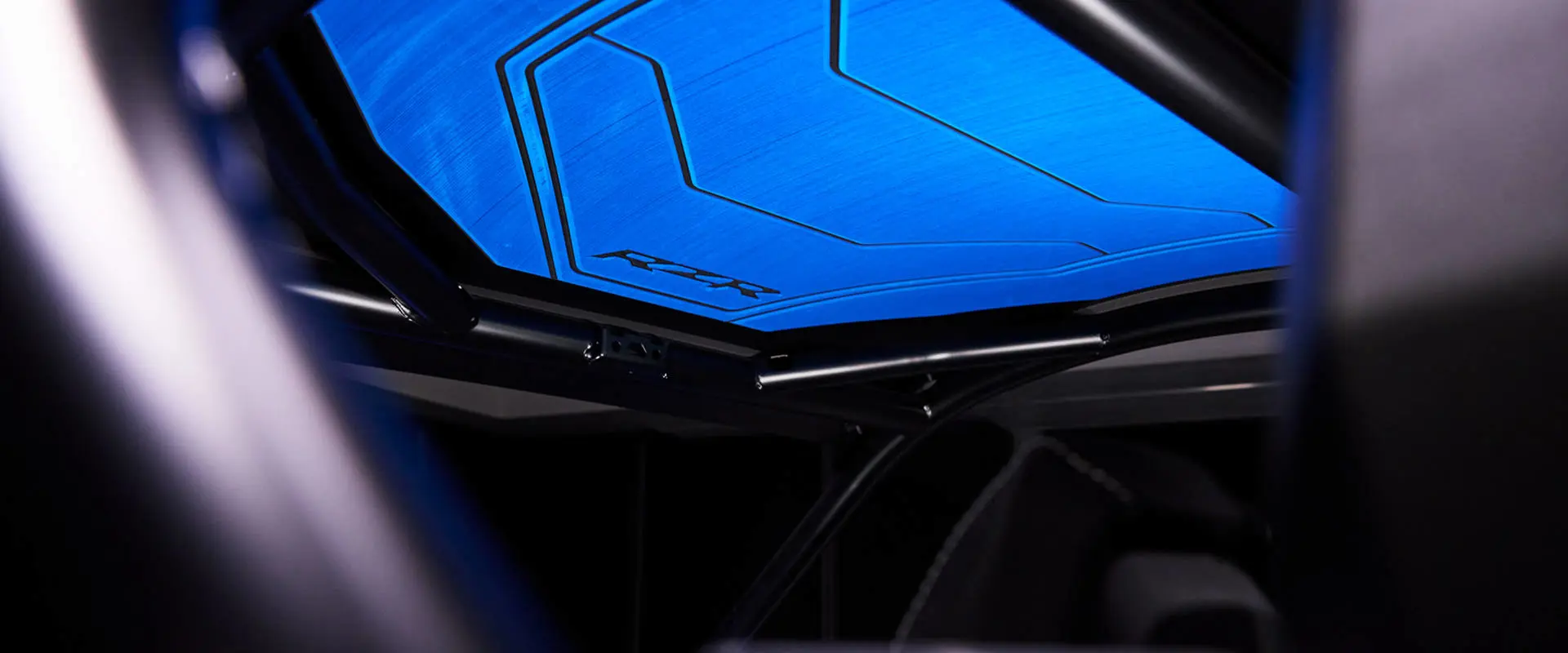 Interior roof view showing the blue paneling and structural roll cage bars of the RZR Pro R Ultra Edition.