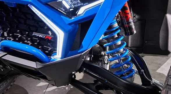 Front suspension detail highlighting the bright blue coil and FOX shock assembly.
