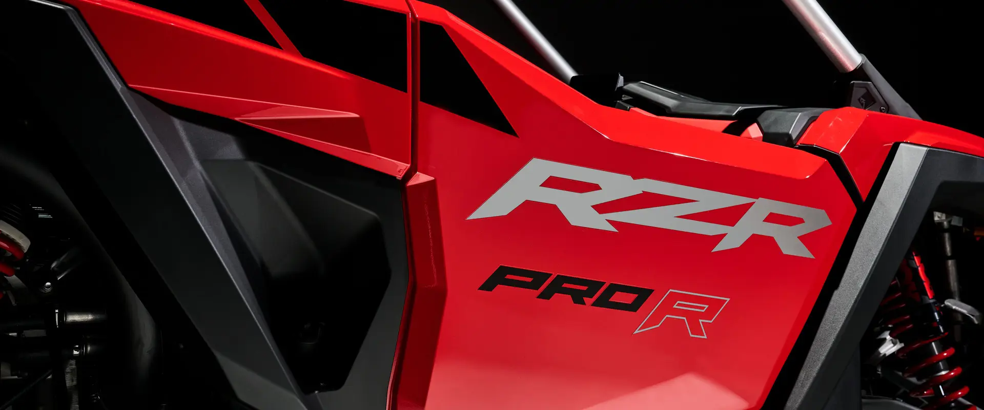Closeup of the RZR badging and half door on an Indy Red 2026 Polaris RZR Pro R SxS.