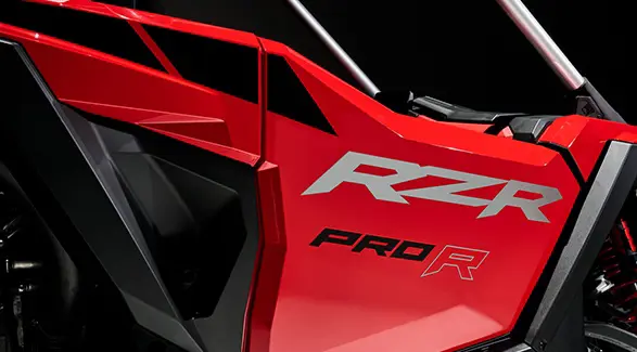 Closeup of the RZR badging and half door on an Indy Red 2026 Polaris RZR Pro R SxS.