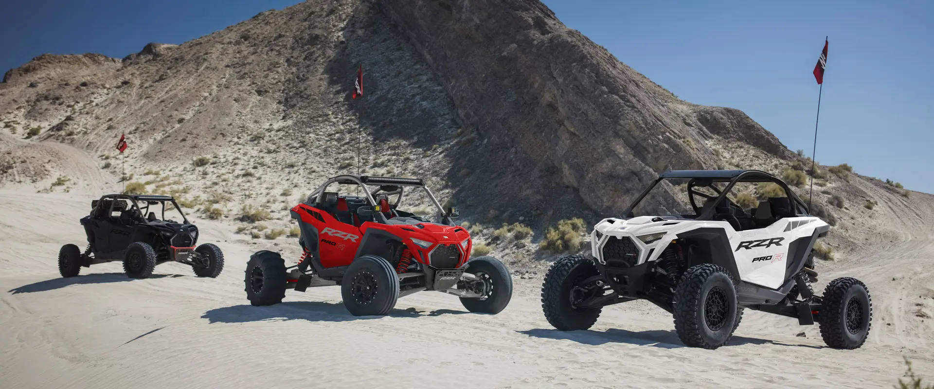 3 2026 Polaris RZR Pro R side-by-sides parked in the desert.