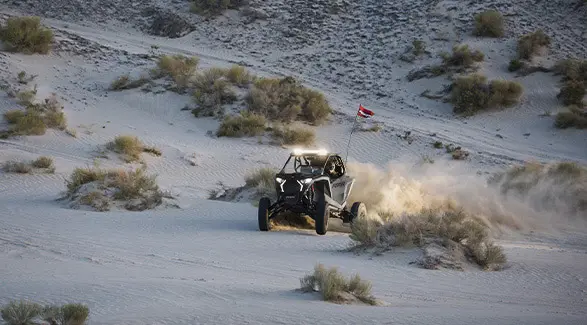 Un Side-by-Side Polaris RZR Pro S Ultimate de 2026 en color Slate Gray recorriendo el desierto.