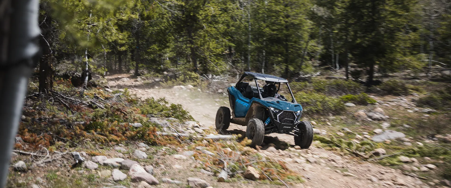 Un Side-by-Side Polaris RZR Pro XP de 2026 atravesando un sendero en el bosque.