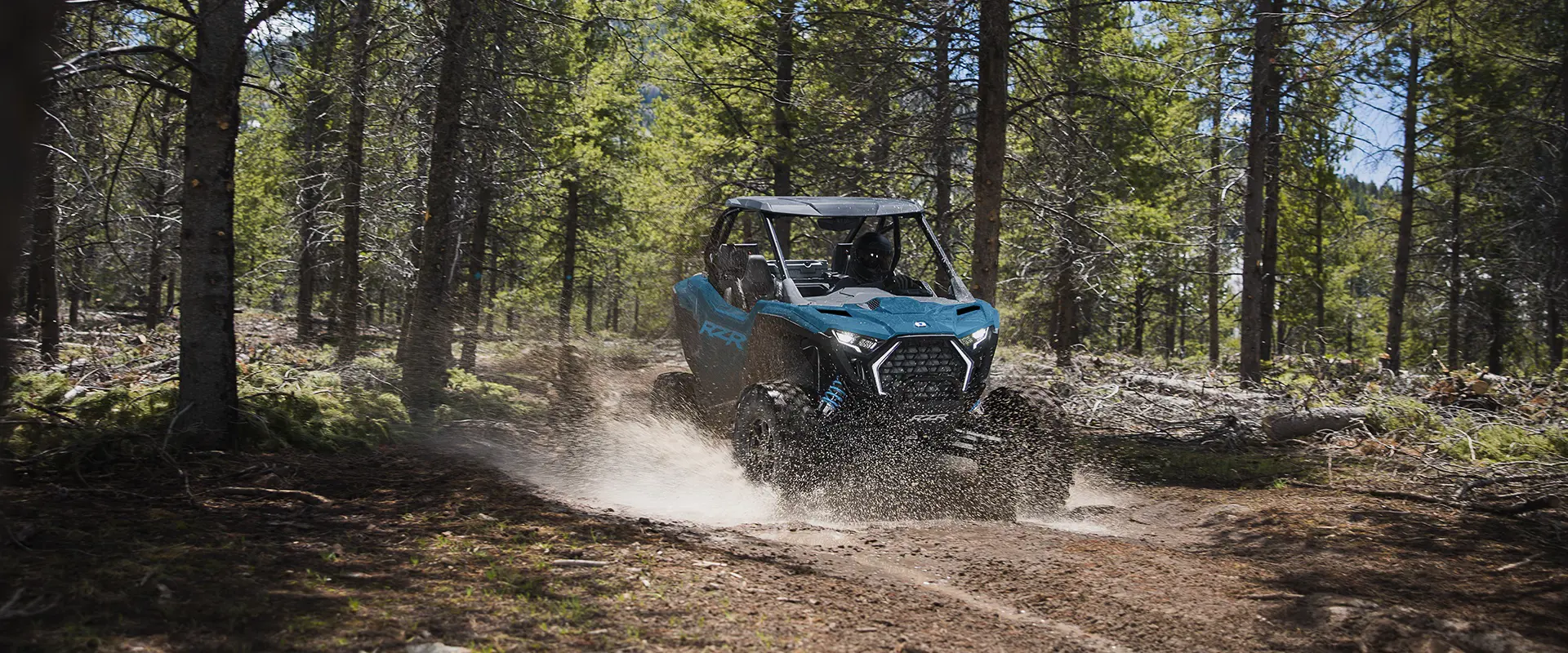 Un Side-by-Side Polaris RZR Pro XP de 2026 atravesando una fosa de lodo en un bosque con facilidad.