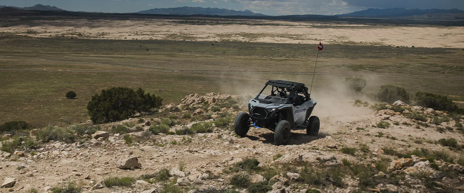Un Side-by-Side Polaris RZR Pro XP de 2026 escalando un terreno rocoso en el desierto.