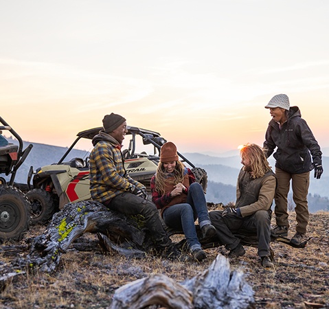 People relaxing after a drive in their 2026 Polaris RZR Trail S side by sides.