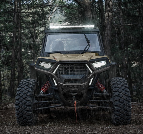 Front end view of a 2026 Polaris RZR Trail S side by side showcasing the advanced LED lighting of a lightbar and headlights.