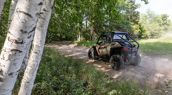 Rear/side view of a 2026 Polaris RZR Trail S side by side on a trail.