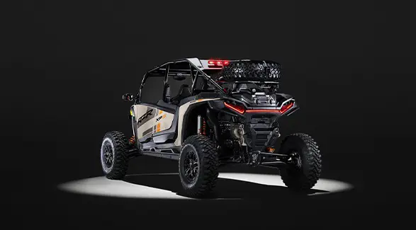 Rear view of a 2026 Polaris RZR XP S 4 SxS entrenched in spotlight in a dark room.