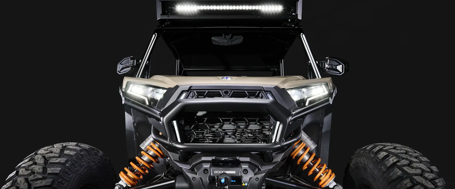 Front end view of a 2026 Polaris RZR XP S 4 SxS entrenched in spotlight in a dark room.