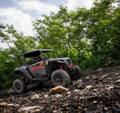 2 riders in a 2026 Polaris RZR XP Ultimate side-by-side crawling over rocky terrain.