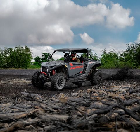 2 riders in a 2026 Polaris RZR XP Ultimate side-by-side showcasing it's strong performance on uneven terrain.