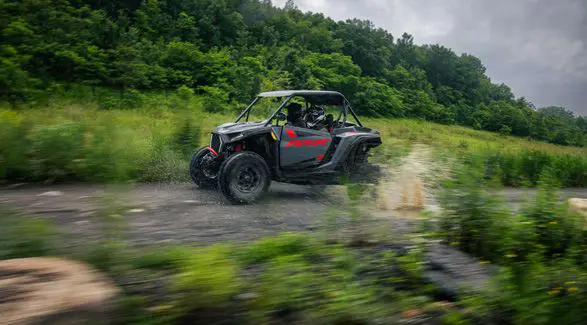 A 2026 Polaris RZR XP Ultimate SxS in the Stealth Gray colorway speeding down a trail.