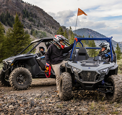 A kid stepping into the passenger seat of a 2027 Polaris RZR 200 EFI youth side-by-side.